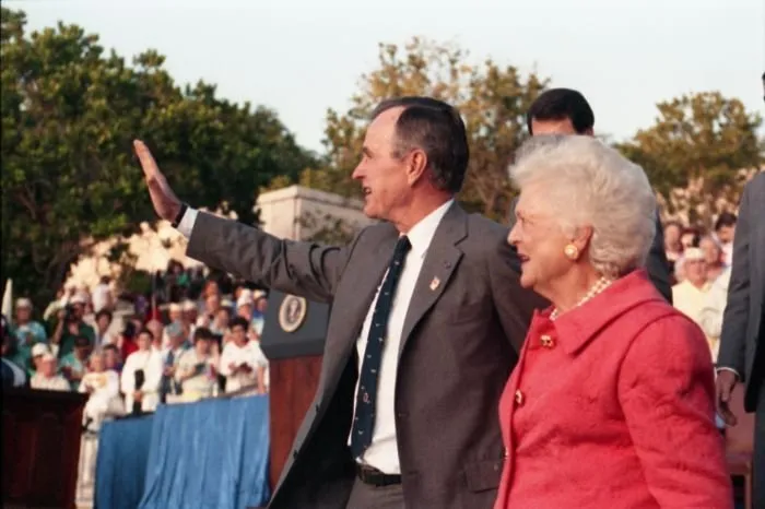 President and Mrs. Bush wave to the crowd at the National Memorial Cemetery of the Pacific following President Bush's speech commemorating the 50th anniversary of the Japanese attack on Pearl Harbor.