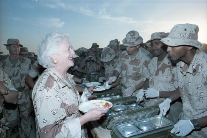First Lady Barbara Bush stands in the "chow line" with Marines from the First Marine Division, waiting to be served Thanksgiving dinner