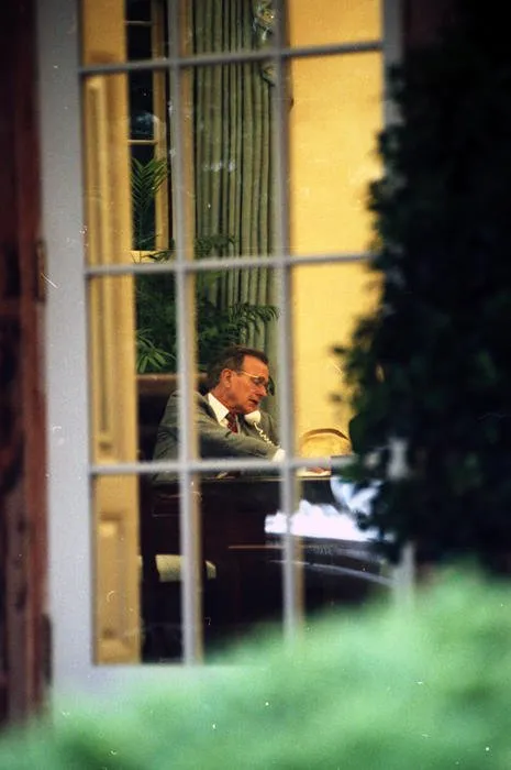 President Bush speaks with British Prime Minister Margaret Thatcher via telephone during a budget meeting in the Oval Office